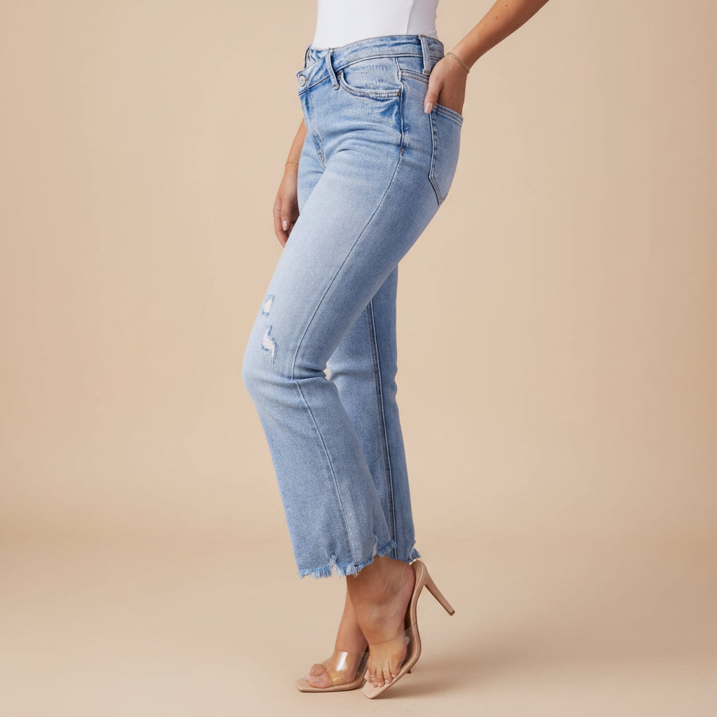 Angled view of women's washed distressed ripped denim jeans